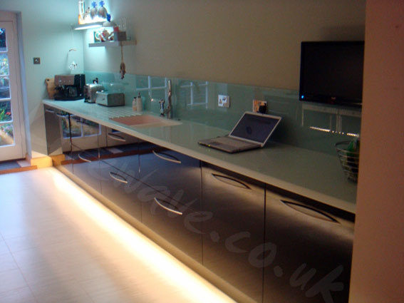 Piano Black Kitchen Cabinets with Warm White LED Tape used to light floor below plinths